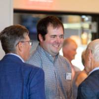 Stuart Jones speaking with two reception guests